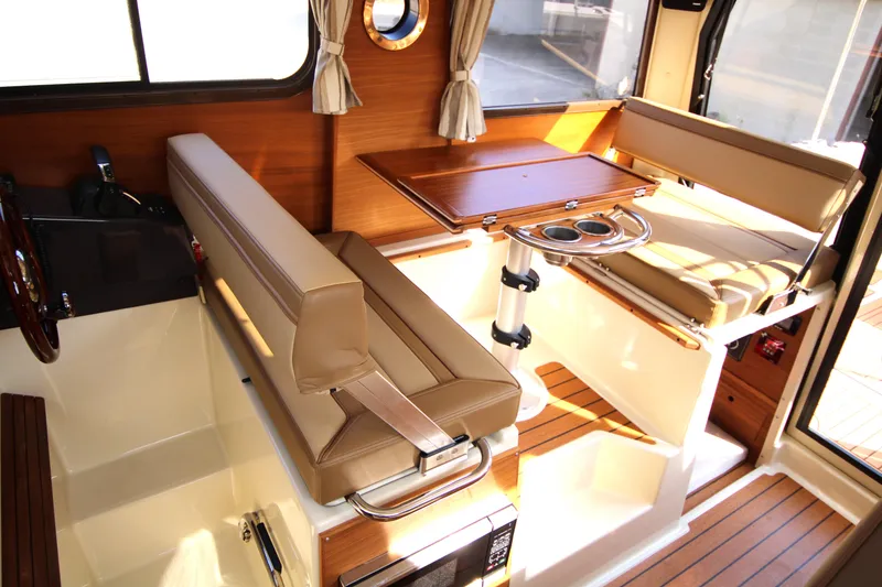 Slide: The Image of 2023 Ranger Tugs R-27 Luxury Edition interior with elegant seating and wooden accents. - 10