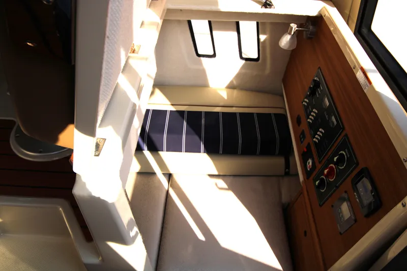 Slide: The Image of Interior of 2023 Ranger Tugs R-27 Luxury Edition, featuring control panel and seating area. - 11