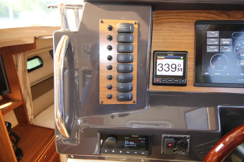 Slide: The Image of 2023 Ranger Tugs R-27 Luxury Edition dashboard with control panel and digital display. - 14