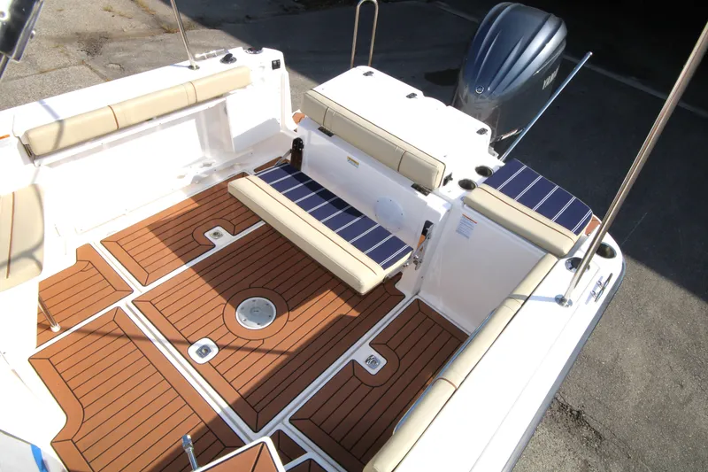 Slide: The Image of 2023 Ranger Tugs R-27 Luxury Edition boat deck with cushioned seating and wood finish. - 18