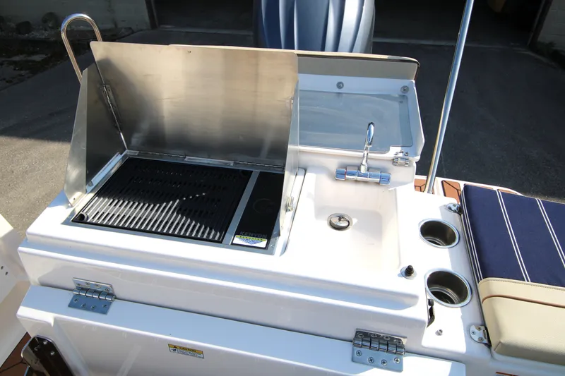 Slide: The Image of 2023 Ranger Tugs R-27 Luxury Edition outdoor kitchen with grill and sink. - 20