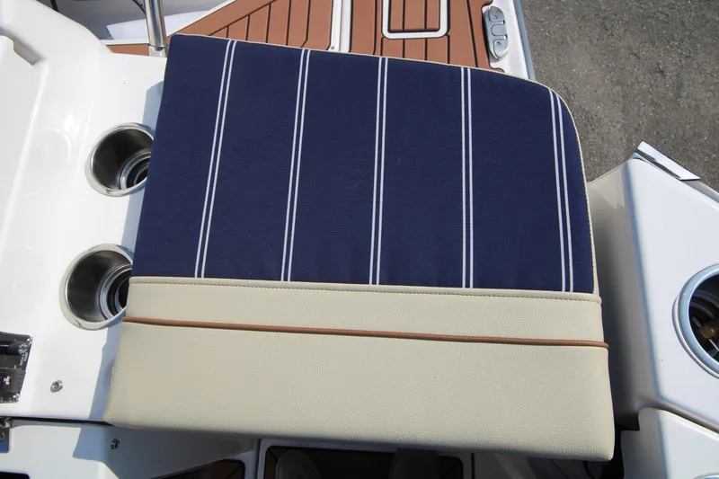 Slide: The Image of 2023 Ranger Tugs R-27 Luxury Edition seat with blue striped cushion and cup holders. - 21