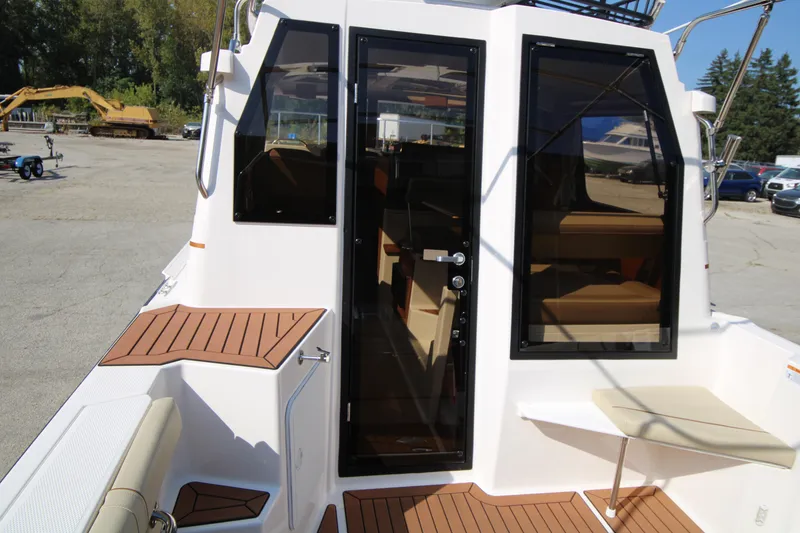 Slide: The Image of 2023 Ranger Tugs R-27 Luxury Edition boat exterior with teak decking and glass doors. - 23