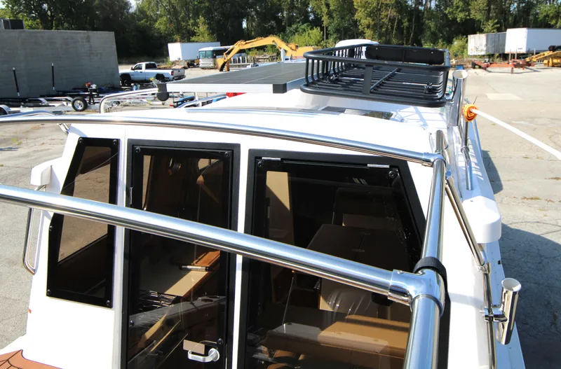 Slide: The Image of 2023 Ranger Tugs R-27 Luxury Edition boat exterior with rooftop railing. - 24