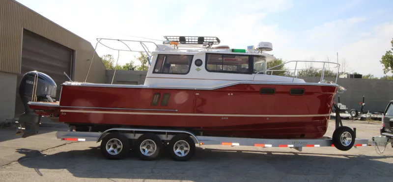 Slide: The Image of 2023 Ranger Tugs R-27 Luxury Edition boat on trailer, red and white exterior. - 6