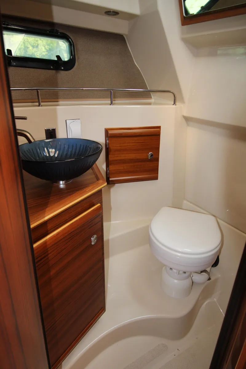 Slide: The Image of 2023 Ranger Tugs R-27 Luxury Edition bathroom with wood cabinetry and modern fixtures. - 9