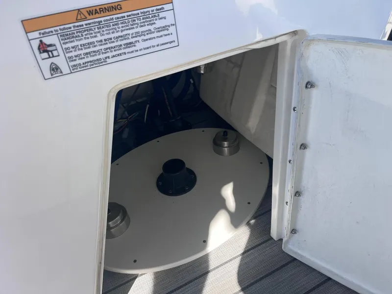 Slide: The Image of Open storage compartment in 2020 Montara Surf Boss boat with warning label. - 12