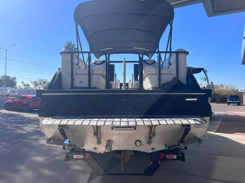 Slide: The Image of 2020 Montara Surf Boss boat, rear view, parked under a canopy on a sunny day. - 15