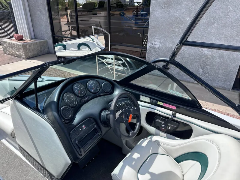 Slide: The Image of Interior of a 2003 Sanger Z210 boat, featuring steering wheel and dashboard controls. - 5