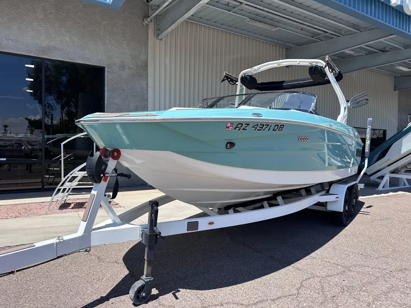 Slide: The Image of 2022 Supreme S220 boat on trailer outside a building. - 2