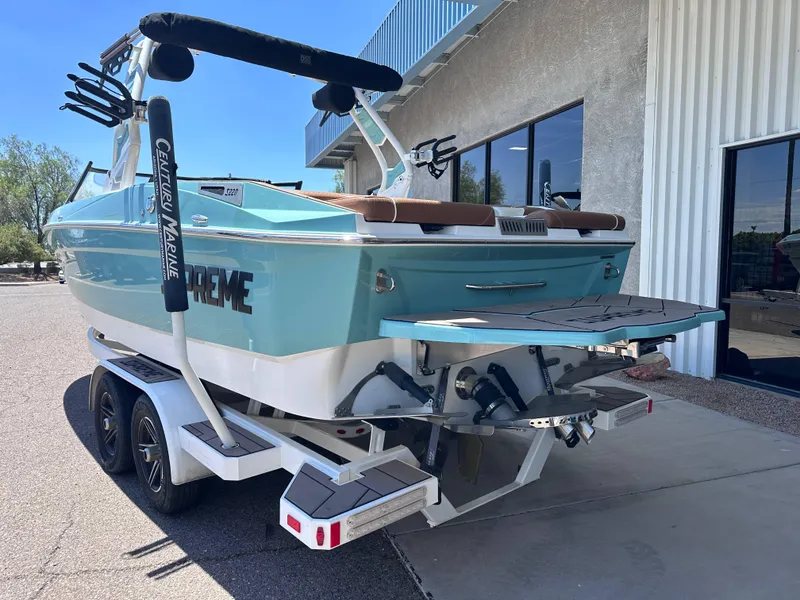 Slide: The Image of 2022 Supreme S220 boat on trailer, parked outside a building. - 3