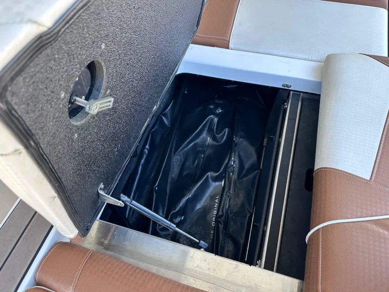 Slide: The Image of 2022 Supreme S220 boat storage compartment with brown and white seating. - 4