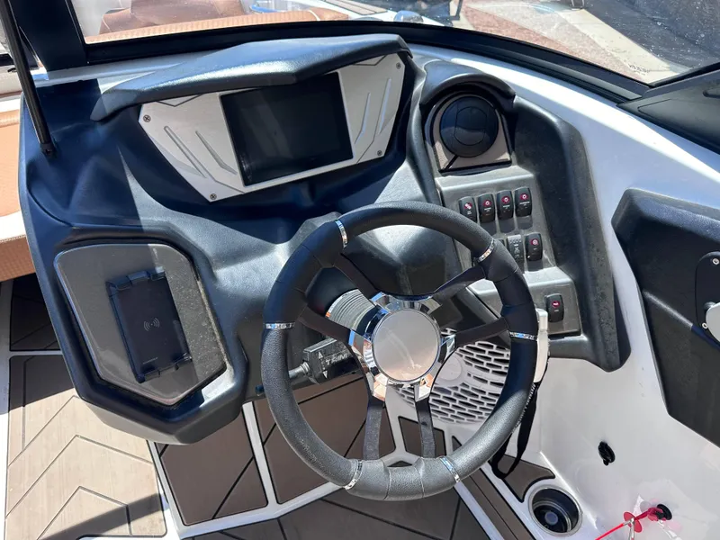 Slide: The Image of 2022 Supreme S220 boat dashboard with steering wheel and control panel. - 5