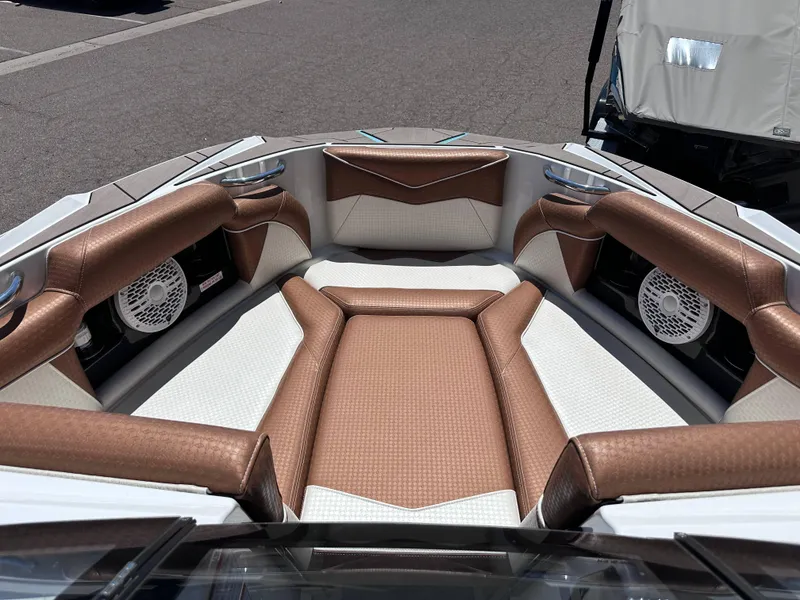 Slide: The Image of 2022 Supreme S220 boat interior with brown and white cushioned seating. - 7