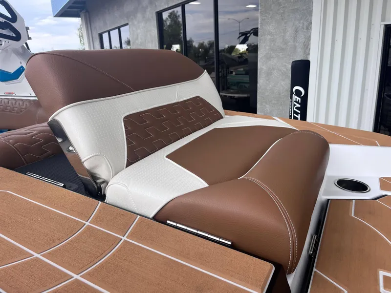 Slide: The Image of 2025 Centurion Ri245 boat seat with brown and white upholstery, outdoor setting. - 12