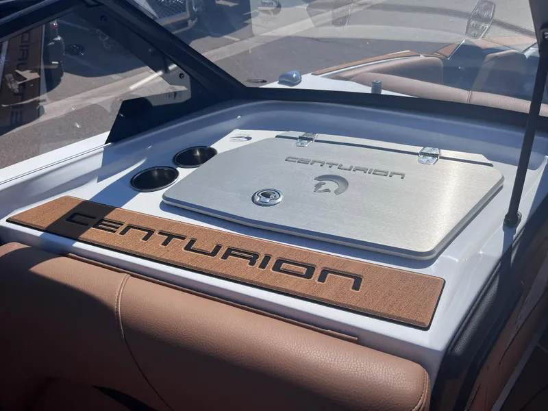 Slide: The Image of 2025 Centurion Fe23 boat interior with branded storage compartment and cup holders. - 11