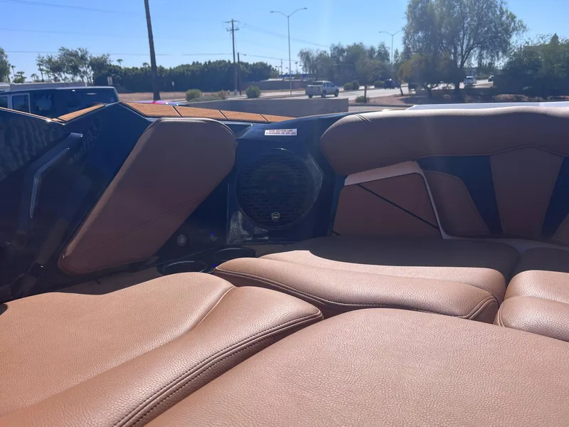 Slide: The Image of 2025 Centurion Fe23 boat interior with tan leather seats and speaker system. - 12