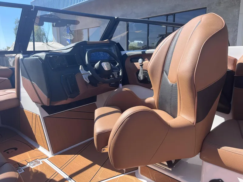Slide: The Image of 2025 Centurion Fe23 boat interior with brown leather seats and modern dashboard. - 4