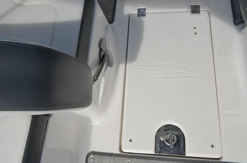Slide: The Image of 2016 Chaparral 250 Suncoast boat interior, featuring a white hatch and seating area. - 18