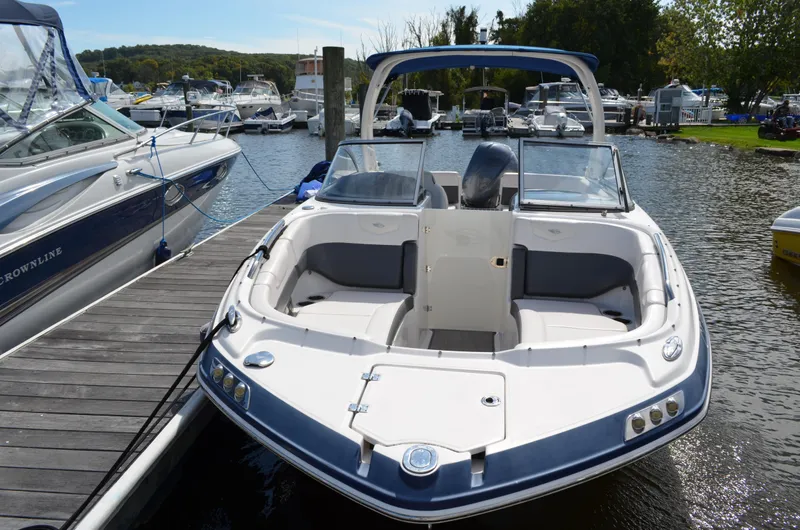 Slide: The Image of 2016 Chaparral 250 Suncoast boat docked at marina, surrounded by other vessels. - 2