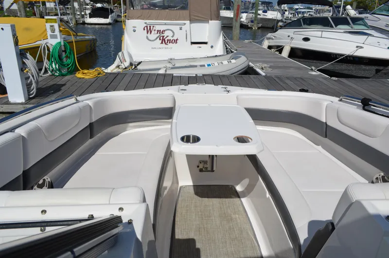 Slide: The Image of 2016 Chaparral 250 Suncoast boat interior with seating and table at marina. - 20