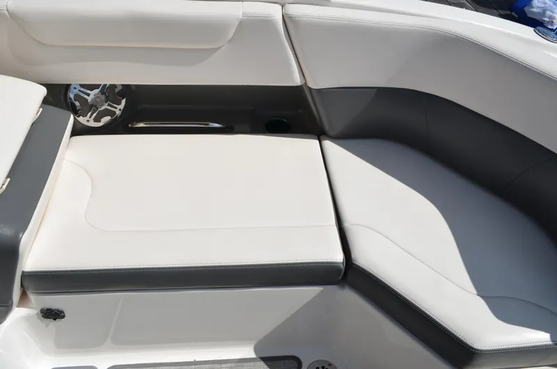 Slide: The Image of 2016 Chaparral 250 Suncoast boat interior seating with white and gray upholstery. - 21