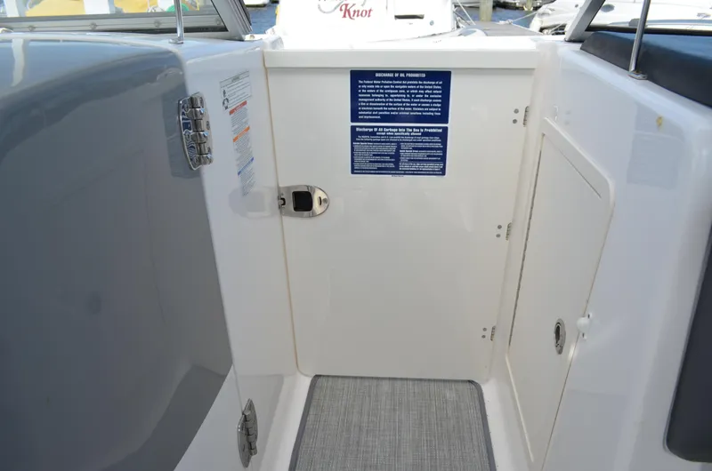 Slide: The Image of 2016 Chaparral 250 Suncoast boat interior with safety instructions and storage compartment. - 32