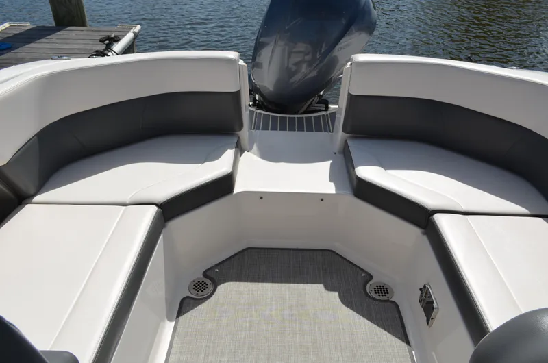 Slide: The Image of 2016 Chaparral 250 Suncoast boat interior with cushioned seating and outboard motor. - 33