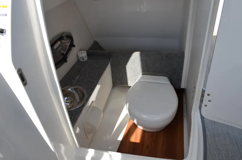 Slide: The Image of 2016 Chaparral 250 Suncoast boat interior bathroom with sink and toilet. - 42