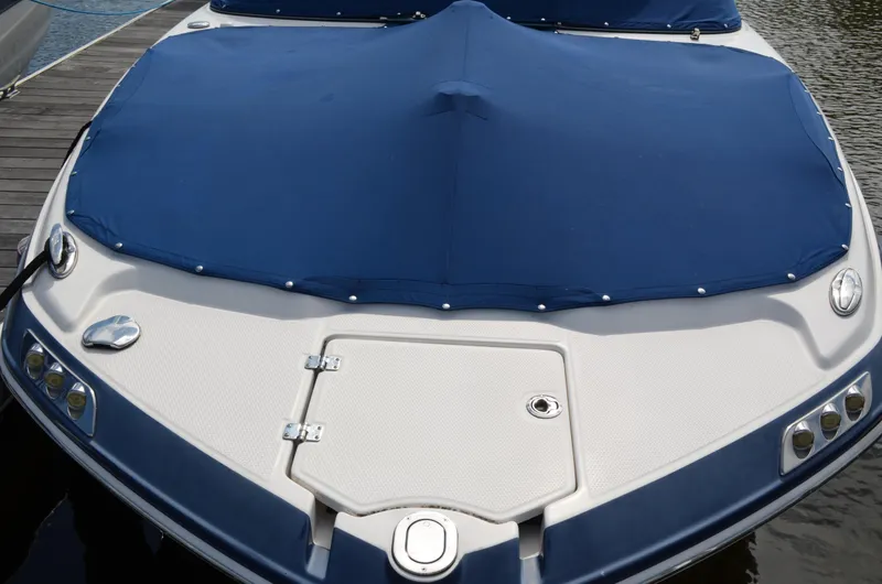 Slide: The Image of 2016 Chaparral 250 Suncoast boat with blue cover docked on water. - 5