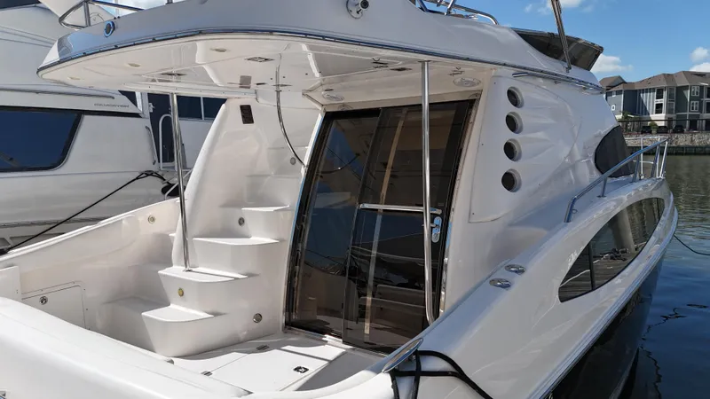 Slide: The Image of 2007 Regal 4080 Flybridge Sedan yacht docked, featuring sleek design and spacious deck. - 15