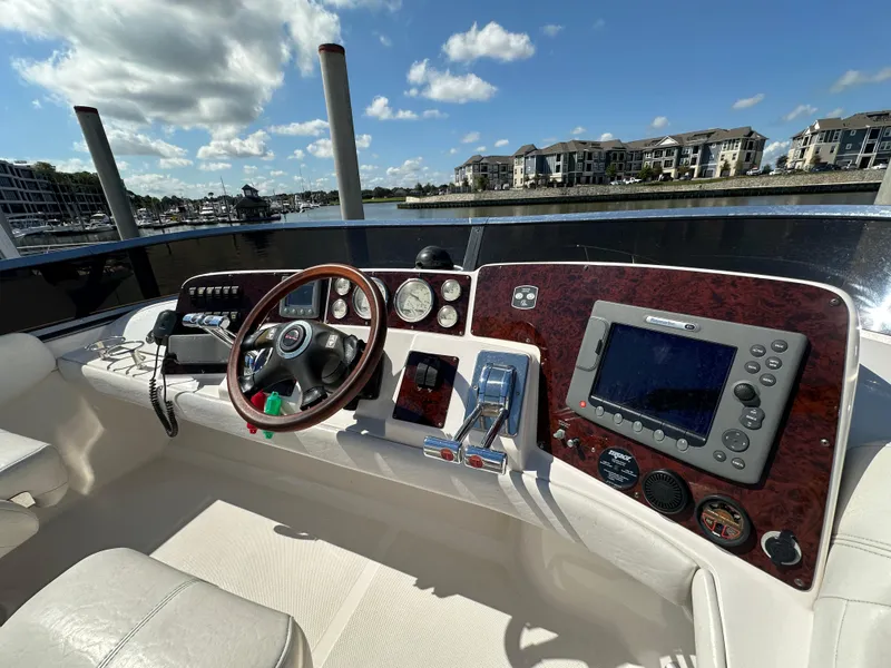 Slide: The Image of 2007 Regal 4080 Flybridge Sedan helm with navigation equipment and waterfront view. - 25
