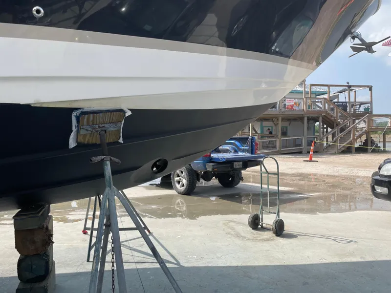 Slide: The Image of 2007 Regal 4080 Flybridge Sedan on dry dock, with supports and vehicle in background. - 65