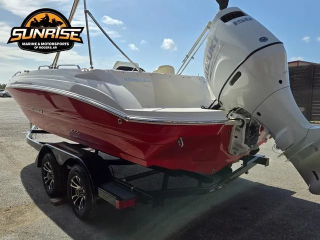 Slide: The Image of 2023 Stingray 192 SC boat with red hull and outboard motor on trailer. - 28