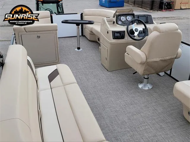 Slide: The Image of 2024 SunCatcher Select 320RCX pontoon boat interior with beige seating and steering console. - 6