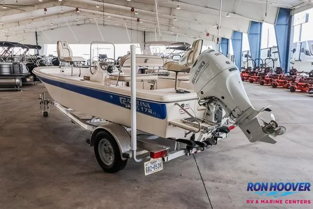 Slide: The Image of 2020 Carolina Skiff 178 boat in showroom, featuring outboard motor and trailer. - 5