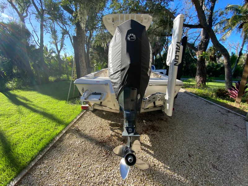 Slide: The Image of 2017 Key West 230 Bay Reef boat with outboard motor, parked on gravel driveway. - 11