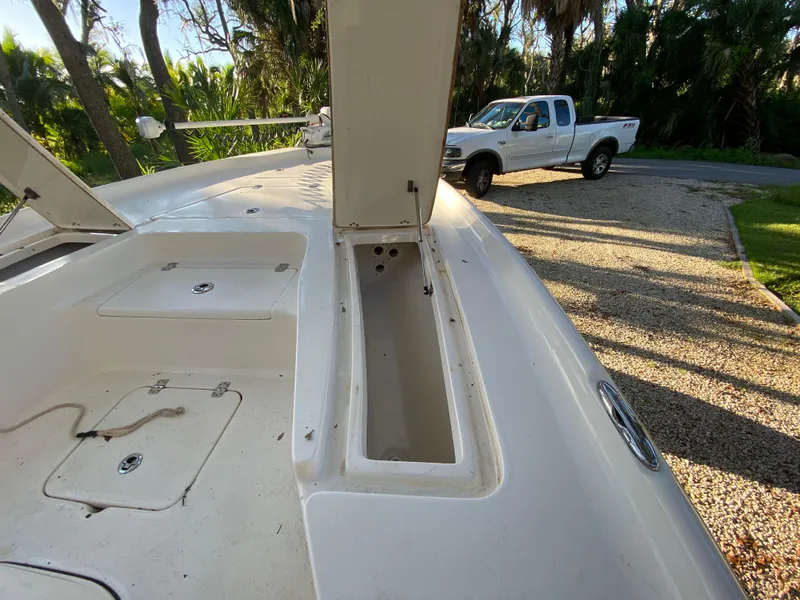 Slide: The Image of 2017 Key West 230 Bay Reef boat with open storage compartments, parked near a white truck. - 20