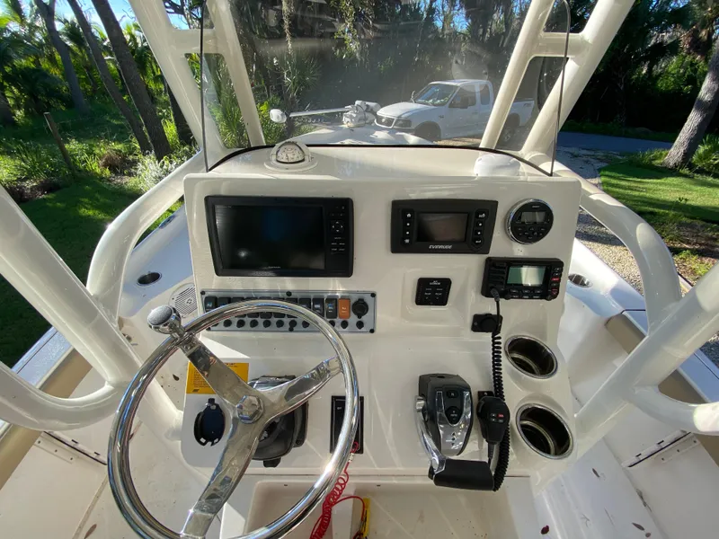 Slide: The Image of 2017 Key West 230 Bay Reef boat dashboard with steering wheel and navigation controls. - 28
