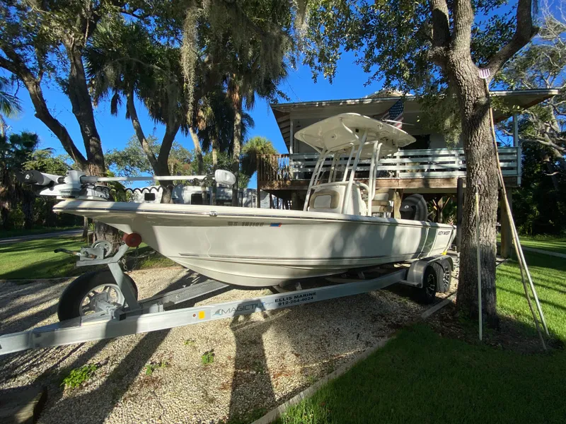 Slide: The Image of 2017 Key West 230 Bay Reef boat on trailer, parked under trees. - 3
