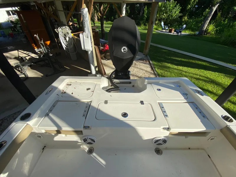 Slide: The Image of 2017 Key West 230 Bay Reef boat interior with motor, docked in a sunny backyard. - 33