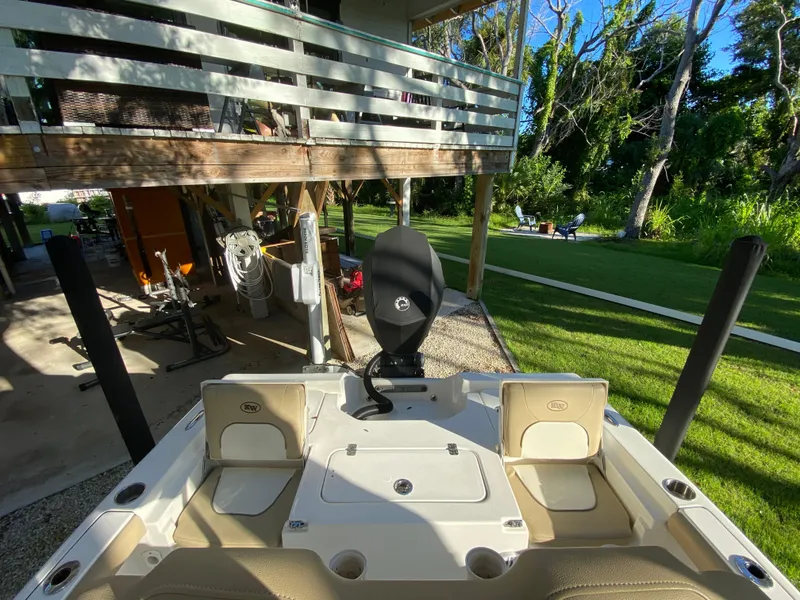 Slide: The Image of 2017 Key West 230 Bay Reef boat parked near a house with lush greenery. - 37