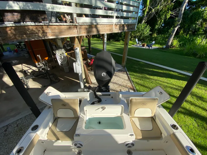 Slide: The Image of 2017 Key West 230 Bay Reef boat with seating and storage, docked near a garden. - 38