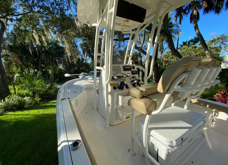 Slide: The Image of 2017 Key West 230 Bay Reef boat interior with helm and seating, surrounded by lush greenery. - 39