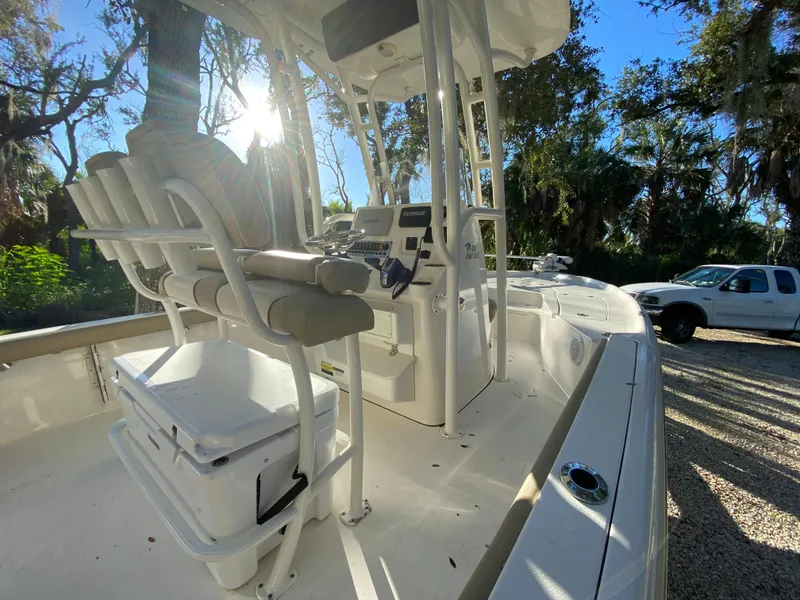 Slide: The Image of 2017 Key West 230 Bay Reef boat interior with seating and console, parked outdoors. - 40