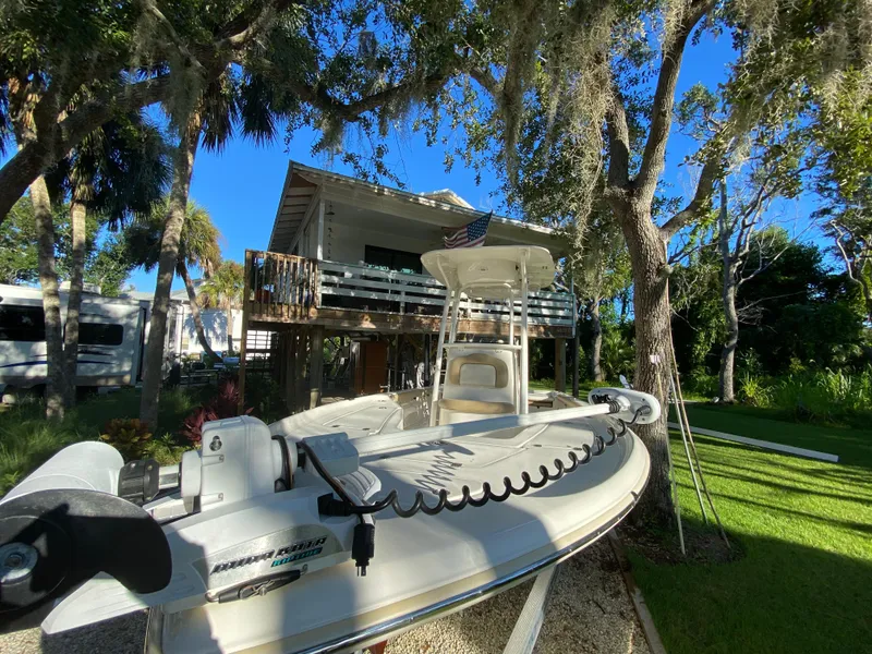 Slide: The Image of 2017 Key West 230 Bay Reef boat in a scenic, tree-lined yard. - 5