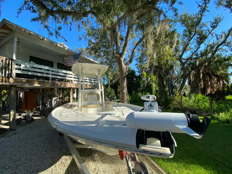 Slide: The Image of 2017 Key West 230 Bay Reef boat parked near a house under trees. - 8