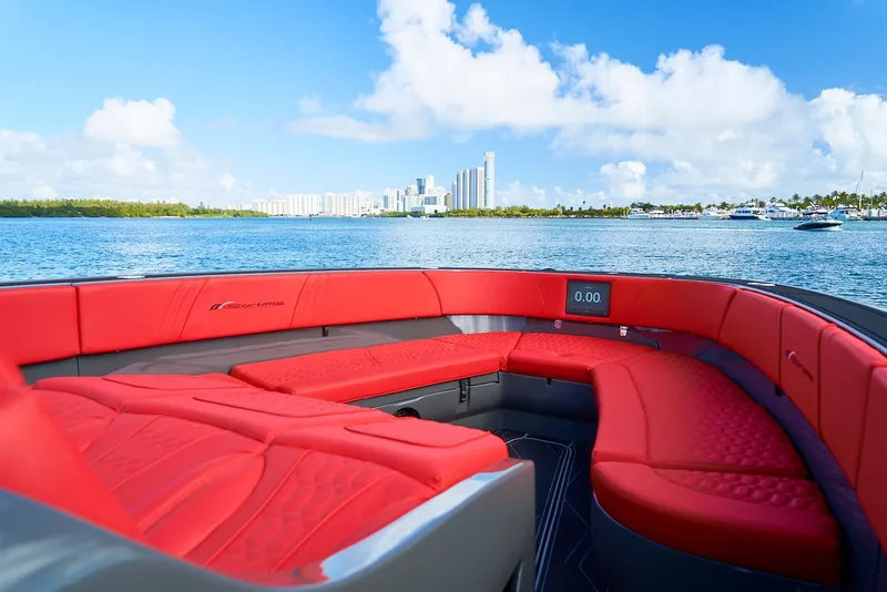 Slide: The Image of Luxury 2021 Midnight Express 43' Solstice boat with red seating, ocean view, and city skyline. - 12