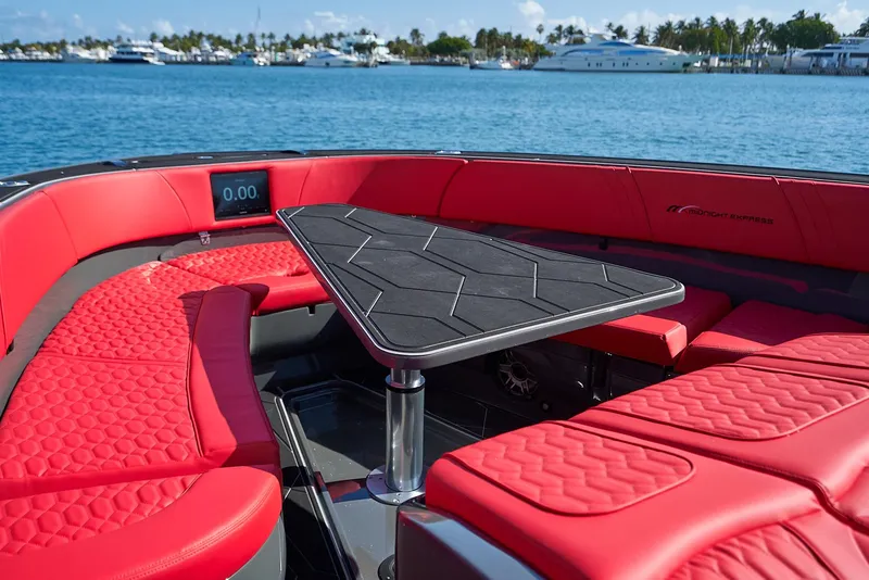 Slide: The Image of Luxurious 2021 Midnight Express 43' Solstice boat with red seating and sleek table on water. - 19