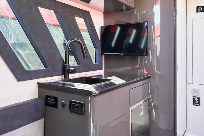 Slide: The Image of Interior of 2021 Midnight Express 43' Solstice yacht with sleek kitchenette and modern TV. - 27